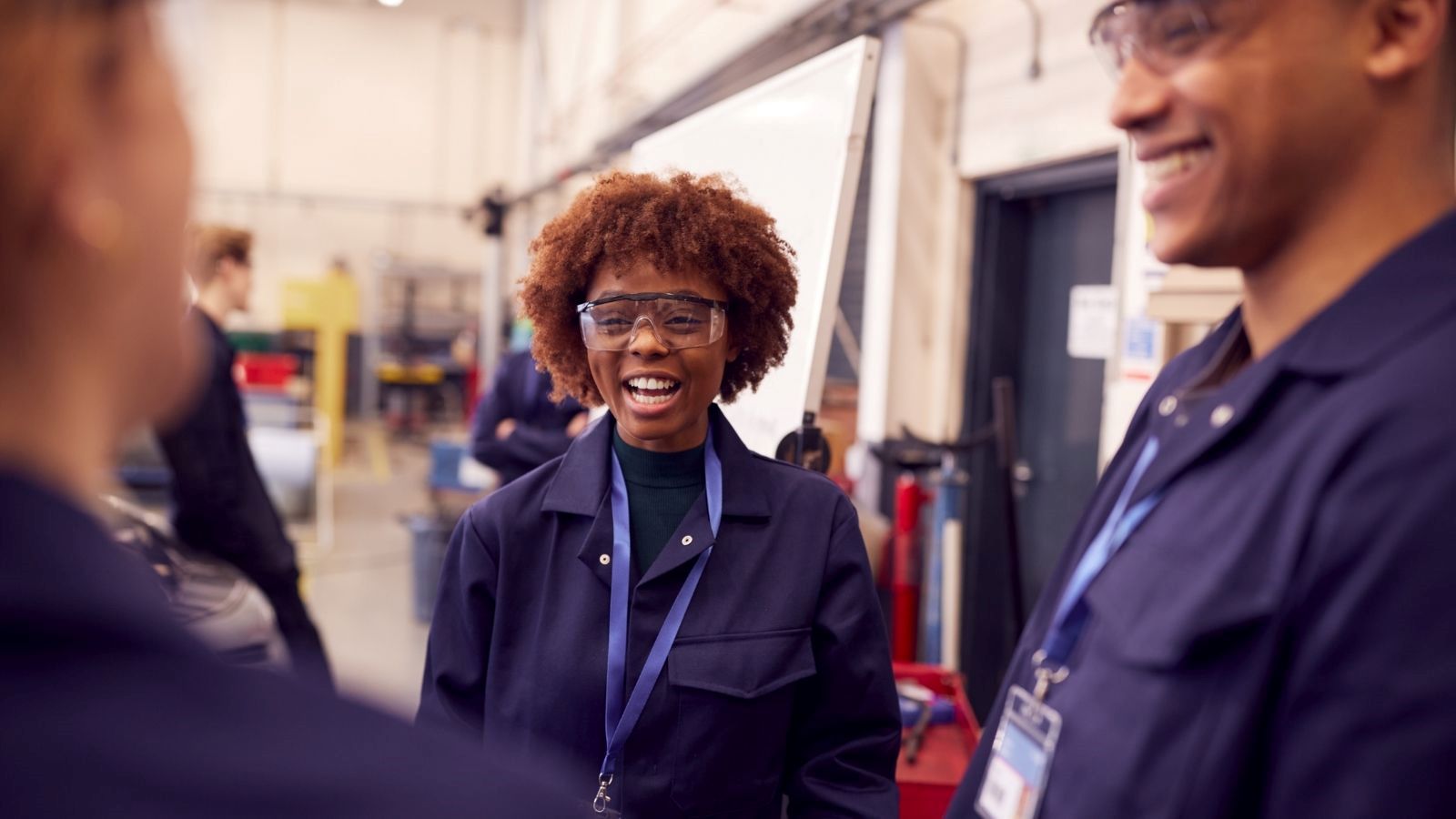 2 apprentices listening as someone is welding.