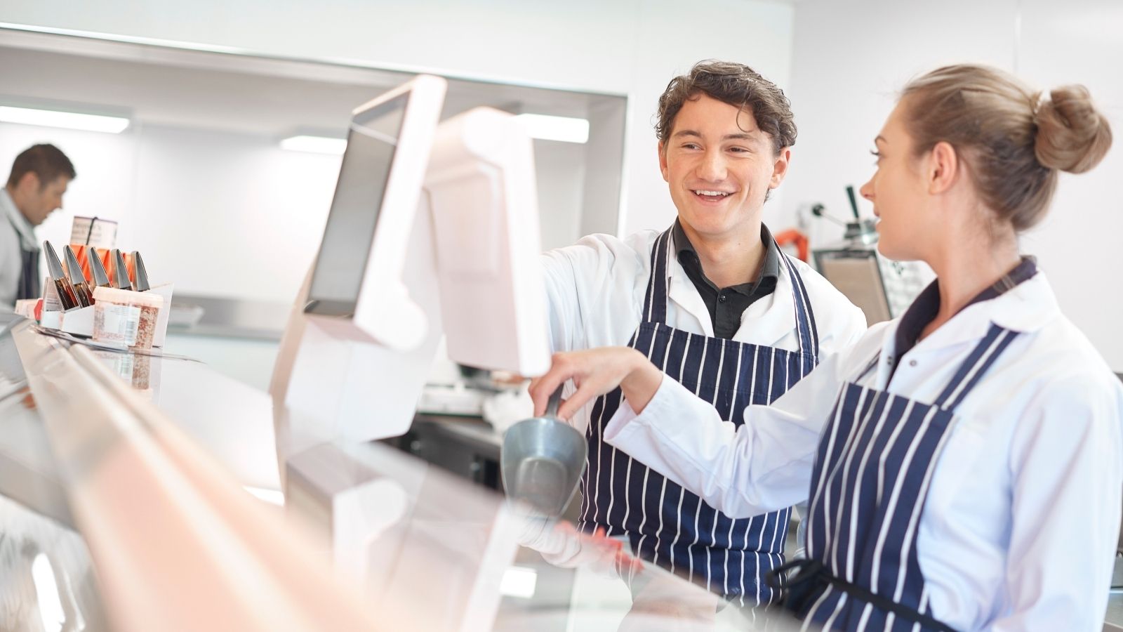 people working behind a fish and chip shop counter