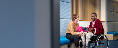 Two people sat opposite each other looking at a careers leaflet