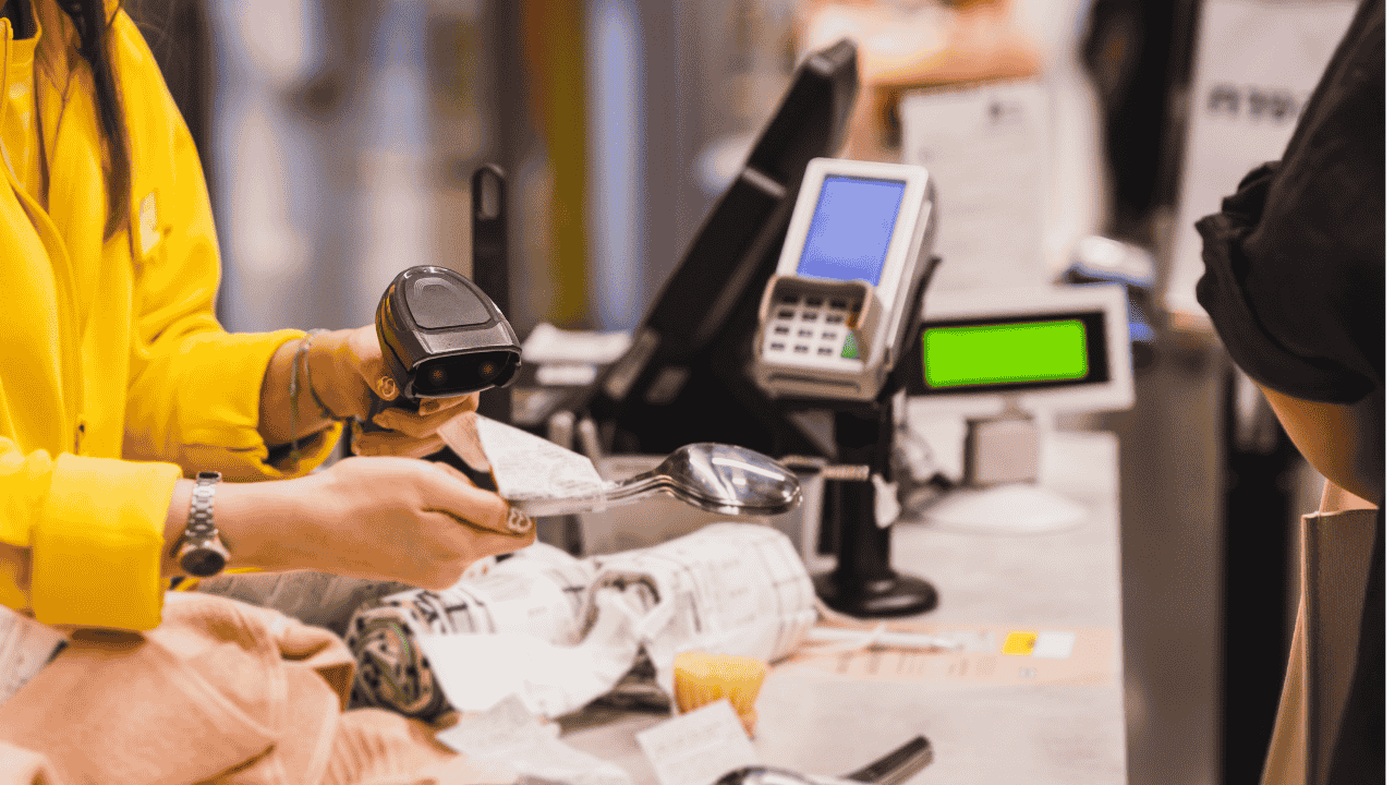 A till and someone scanning an item