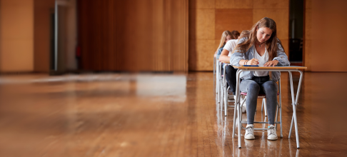 Group of students sat in an exam hall. 