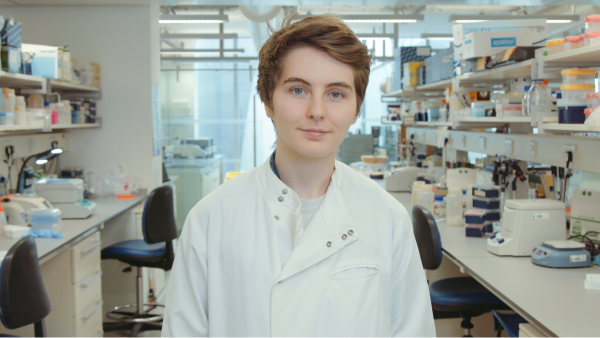 A person wearing a white lab coat stood in a laboratory setting.