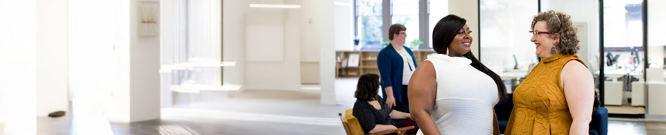 Two people chatting in office setting.
