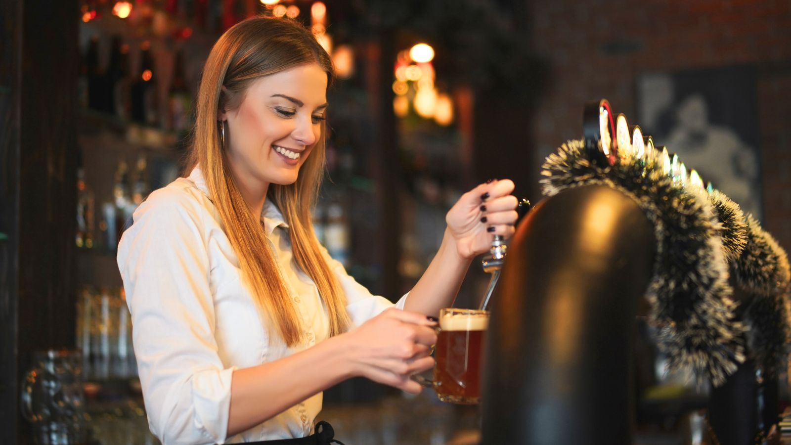 A bar tender pouring a drink. 