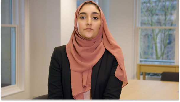 A woman sitting next to a table in a bright office.