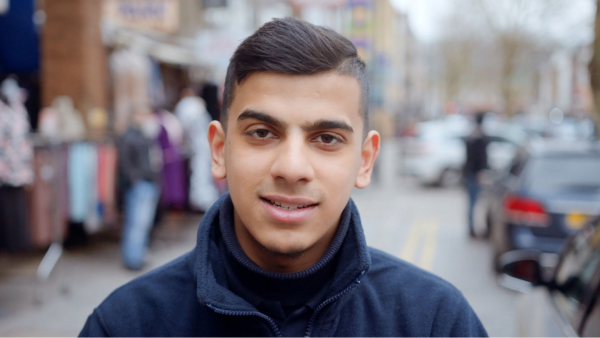 A young man stood on the pavement of a busy street.